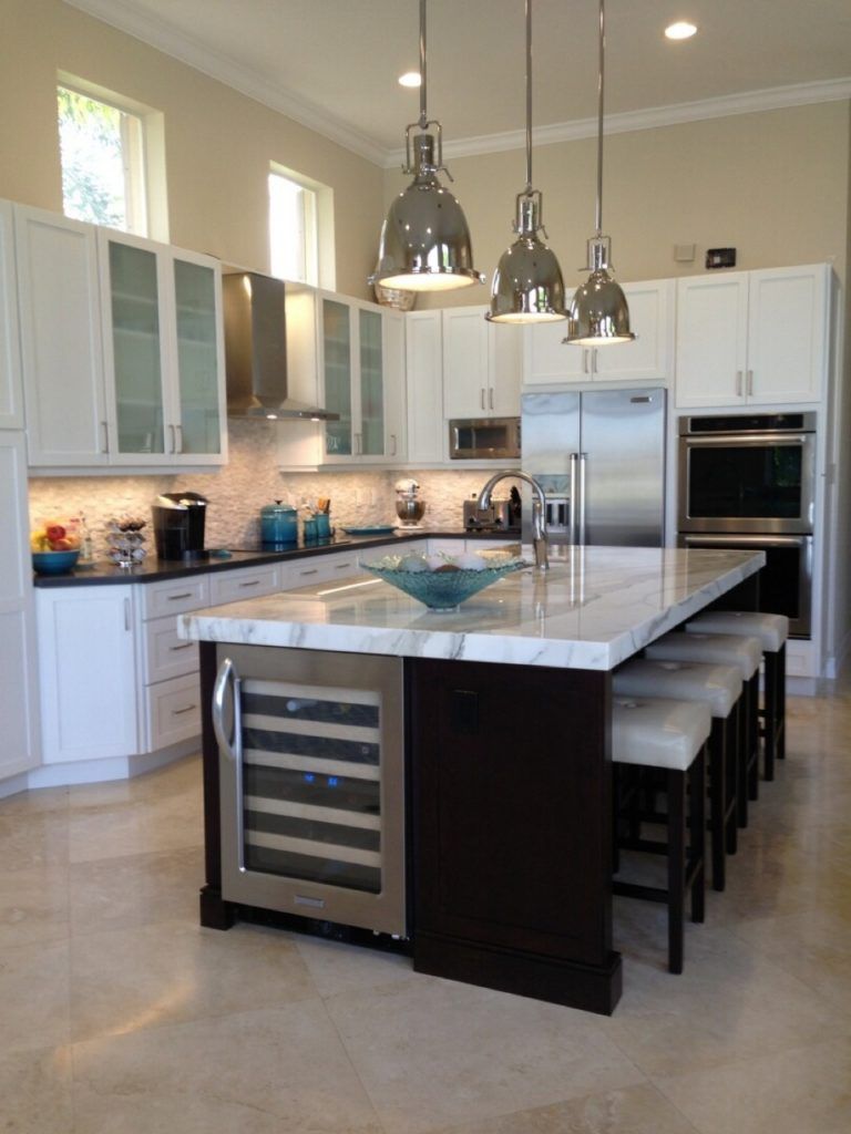 Modern kitchen with white cabinets, stainless steel appliances, island, and pendant lights