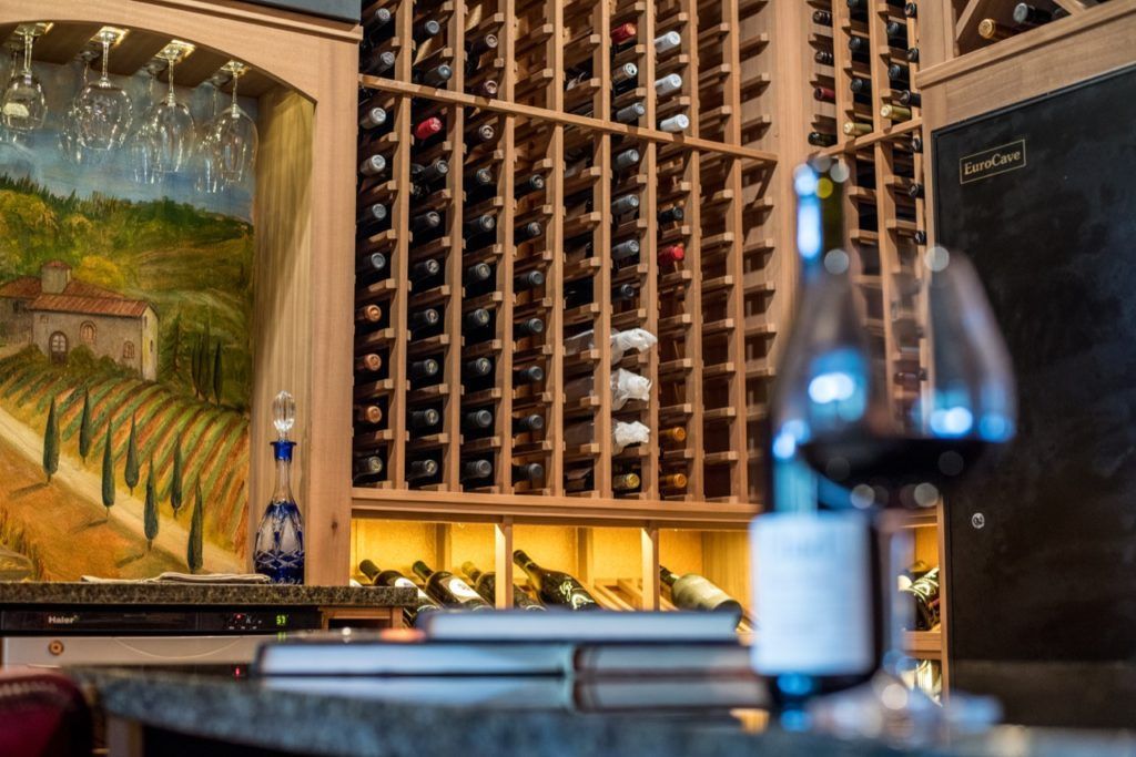 Wine cellar with wall-mounted racks and a blurred wine bottle in the foreground