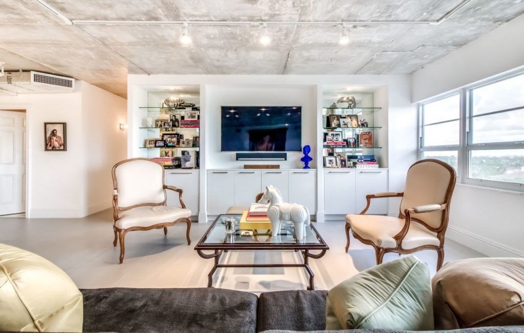 Living room with white built-in cabinets, two ornate chairs, and a glass-top coffee table.