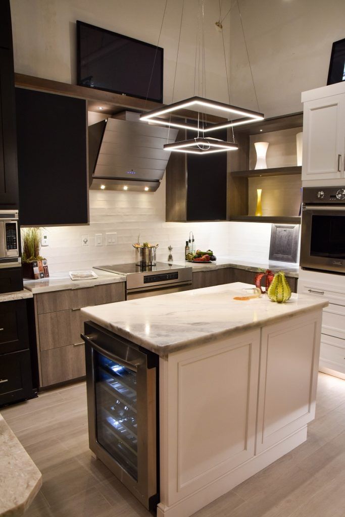 Modern kitchen with white cabinets, marble island, black accents, and pendant lighting
