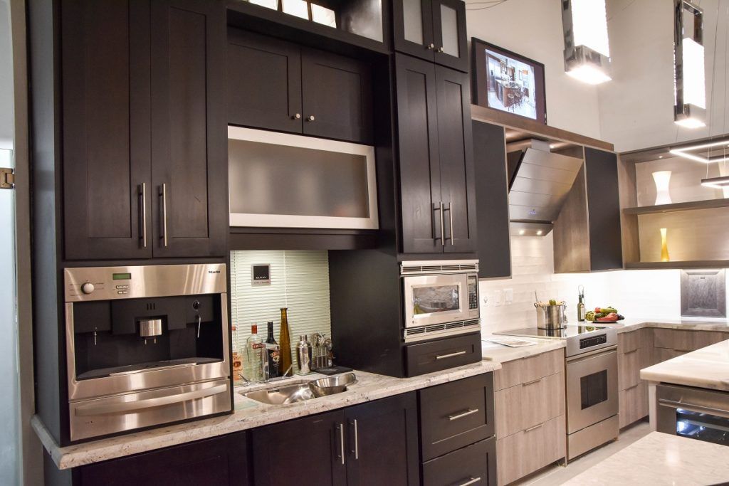 Modern kitchen with dark cabinets, stainless appliances, and a granite countertop