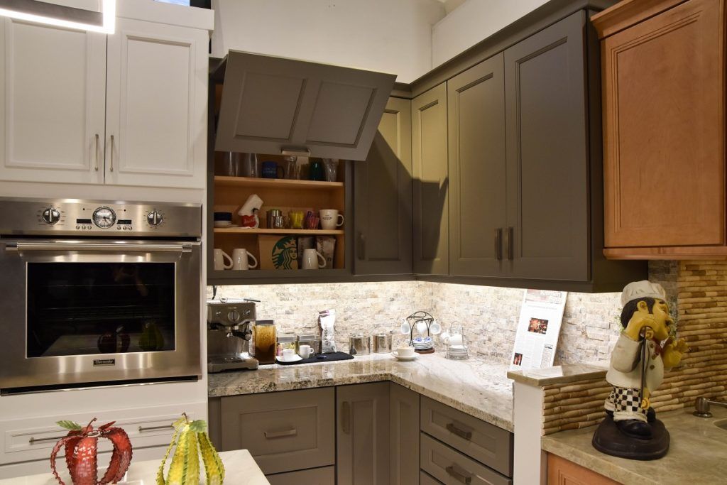 Modern kitchen with white cabinets, granite counters, built-in oven, and a small pantry nook