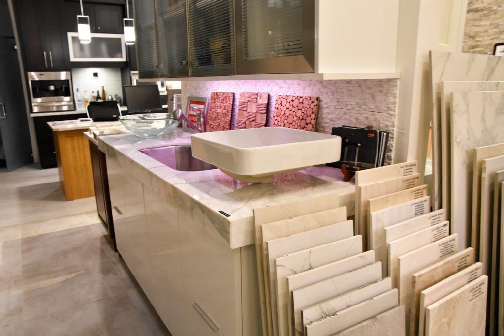Kitchen showroom with a central island and stacked white tile samples on display