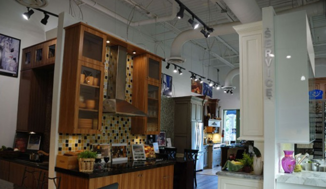 Modern café interior with wooden cabinets, white columns, hanging lights, and a seating area near the window