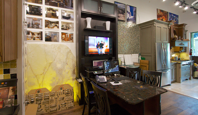 Cozy kitchen-dining area with a black table, cabinets, wall photos, and a TV on a counter.
