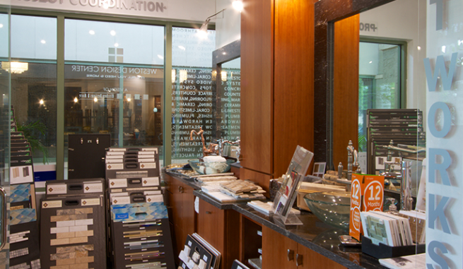 Store checkout counter with display racks, brochures, and a glass entrance reflecting lights