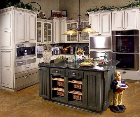 Modern kitchen with white cabinets, dark island, pendant lights, and a decorative figurine near the counter