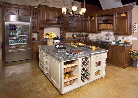 Spacious kitchen with dark wood cabinets, large island, and stainless steel refrigerator.