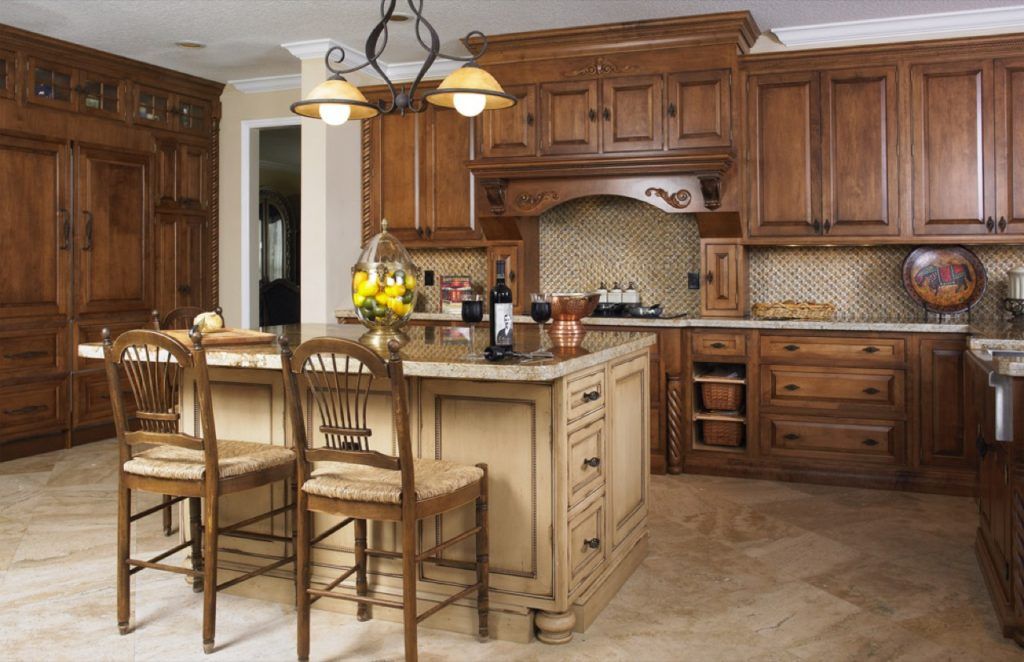 Warm kitchen with wood cabinets, island seating, pendant lights, and beige tile floor