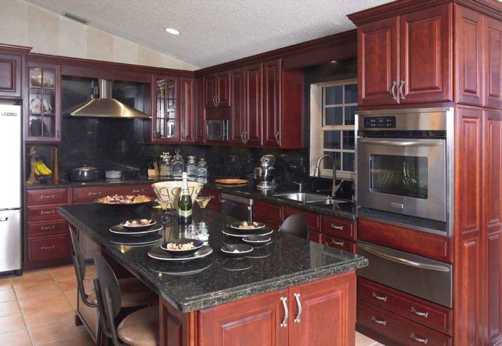 Elegant kitchen with dark wood cabinets, black granite island, and stainless steel appliances
