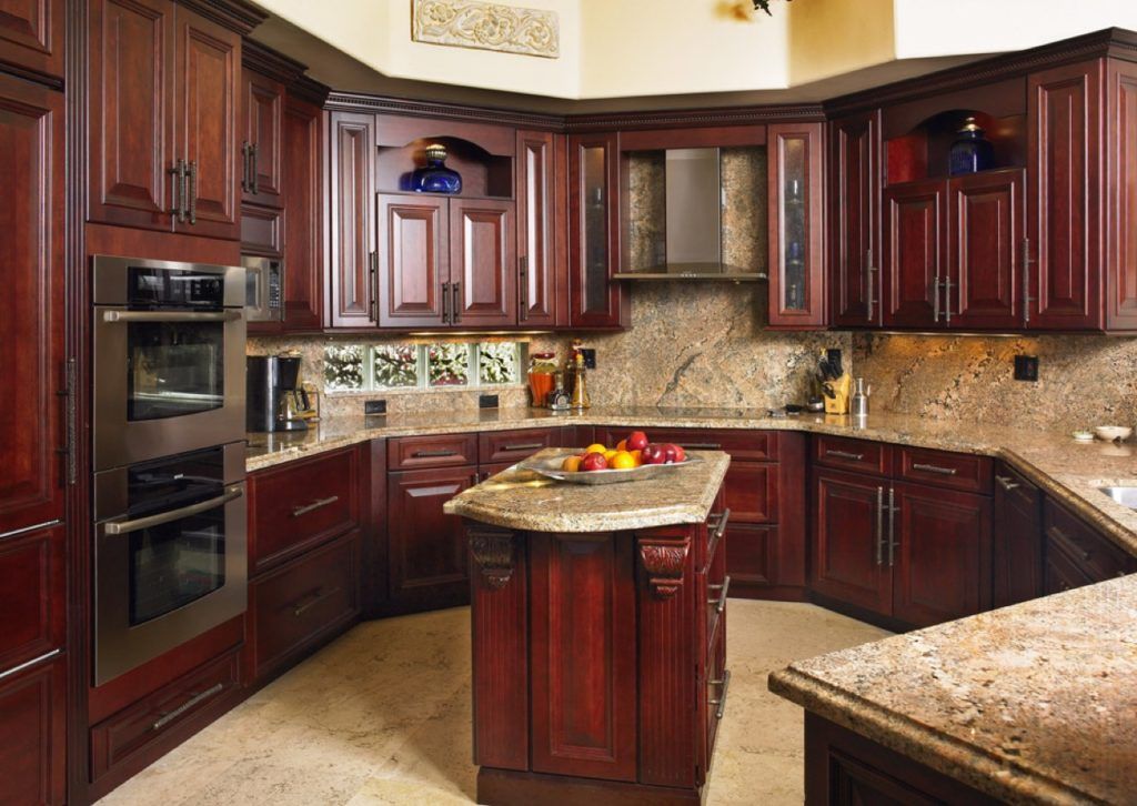 Elegant kitchen with dark wood cabinets, granite countertops, and a central island with fruit bowl.