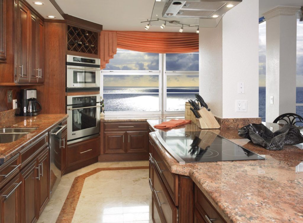 Modern kitchen with dark wood cabinets, granite counters, and a large window over the sink.