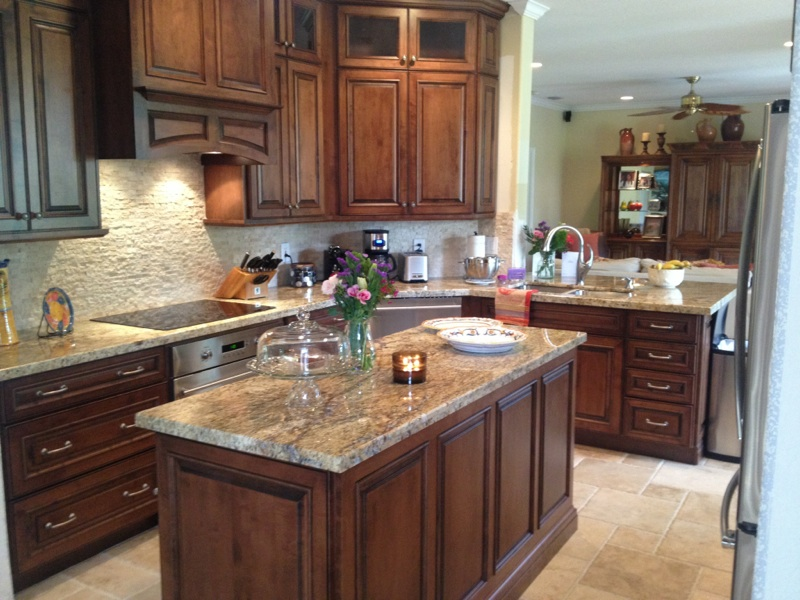 Modern kitchen with dark wood cabinets, granite island, and stainless steel appliances