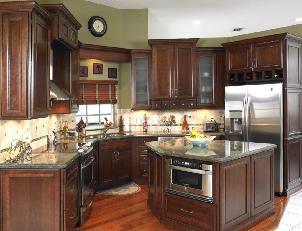 Spacious kitchen with dark wood cabinets, granite countertops, stainless steel appliances, and warm hardwood floors