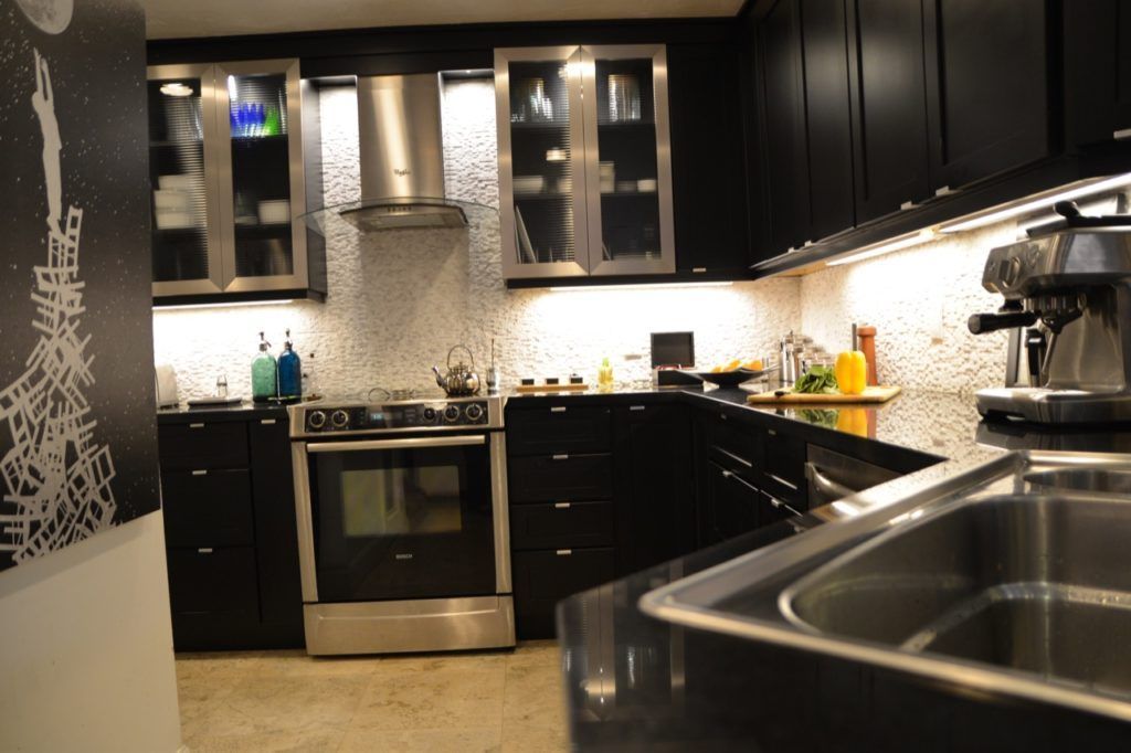 Modern black-and-stainless kitchen with stove, cabinets, countertop, and double sink