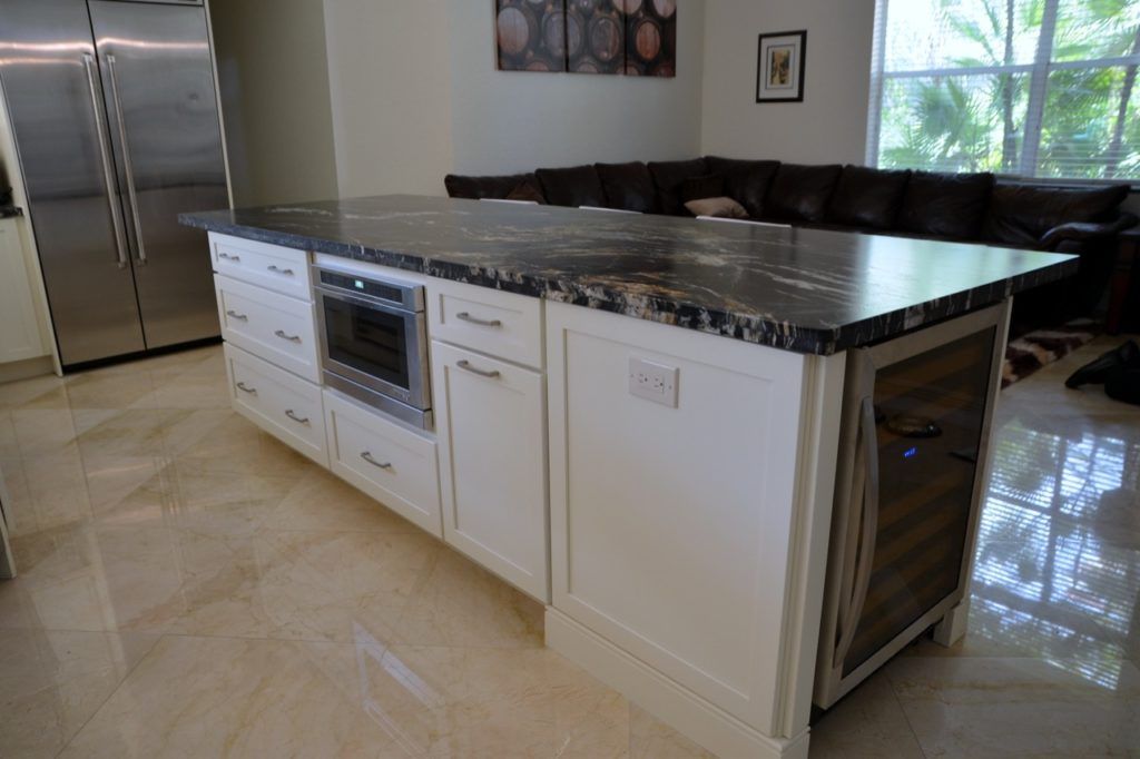 Modern kitchen with white cabinets, stainless steel appliances, and a dark island countertop