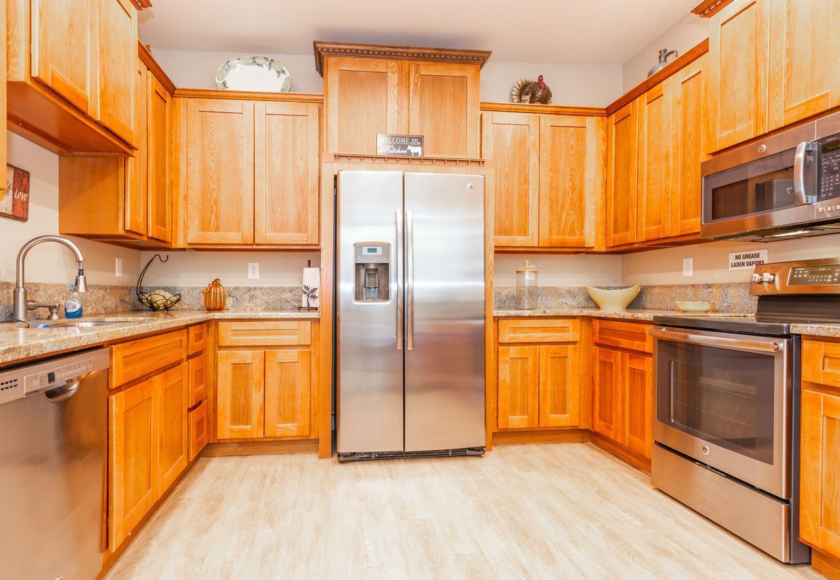 Kitchen with light wood cabinets, stainless steel appliances, and granite countertops.