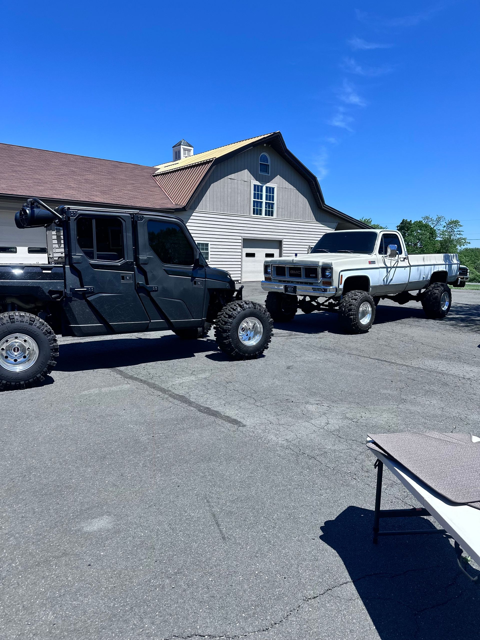 A jeep and a truck are parked in front of a house