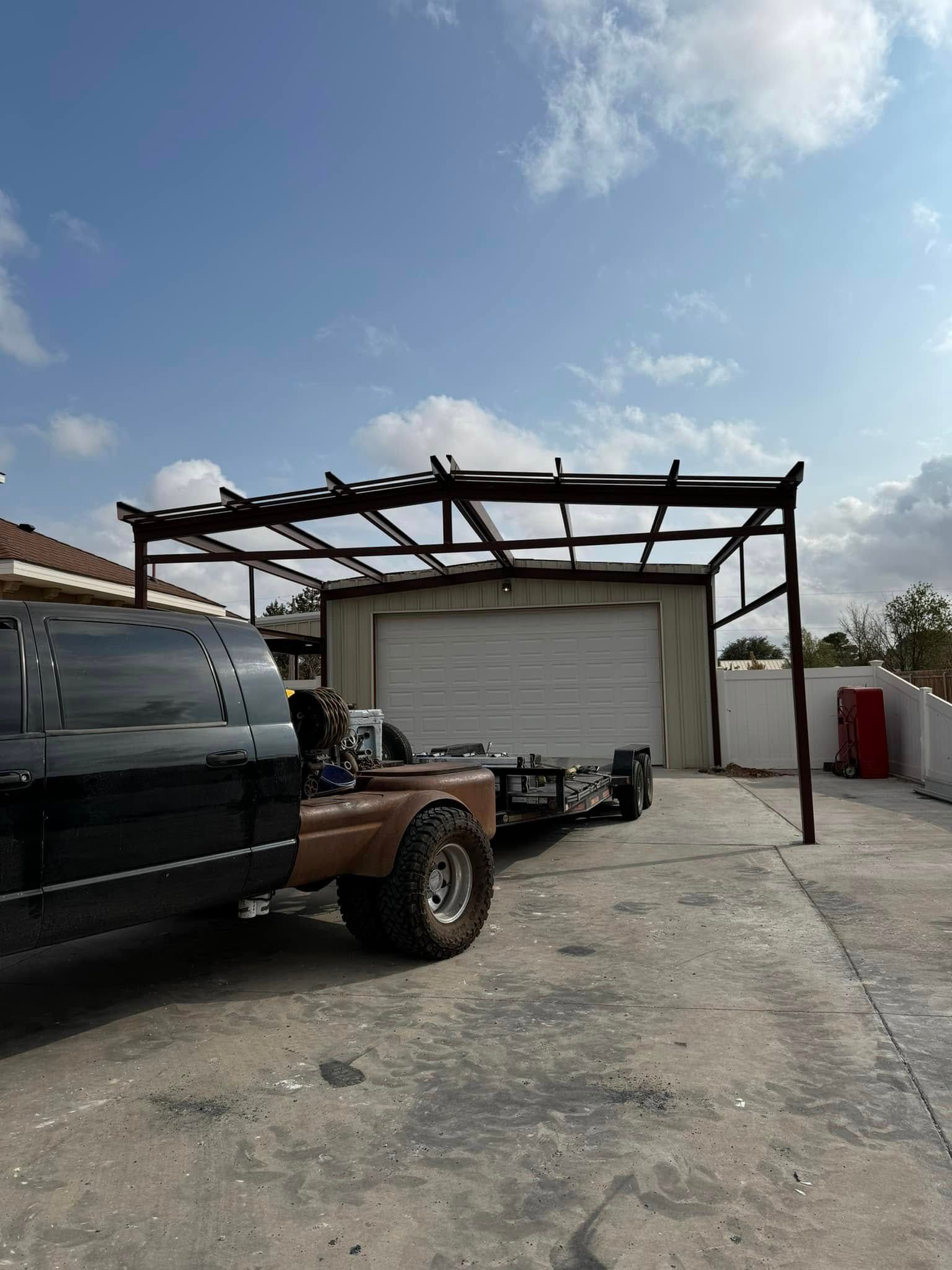 Pickup truck parked beside a metal-framed carport and white garage on a sunny driveway