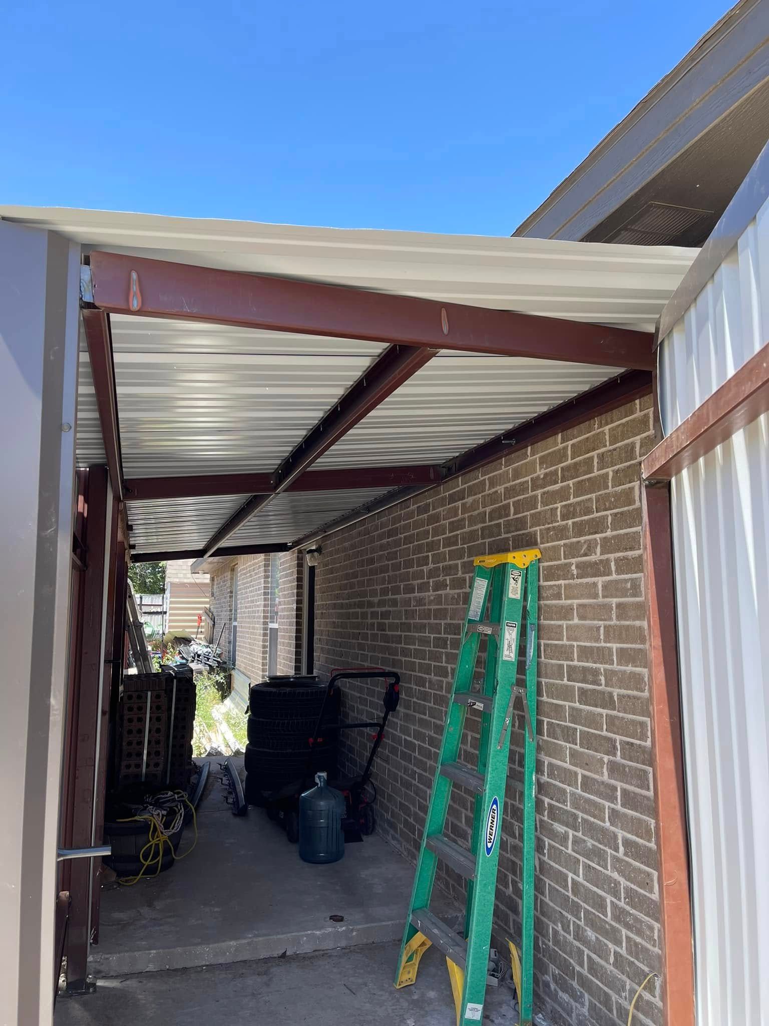 Covered brick side yard with a corrugated roof, green ladder, and trash bins.
