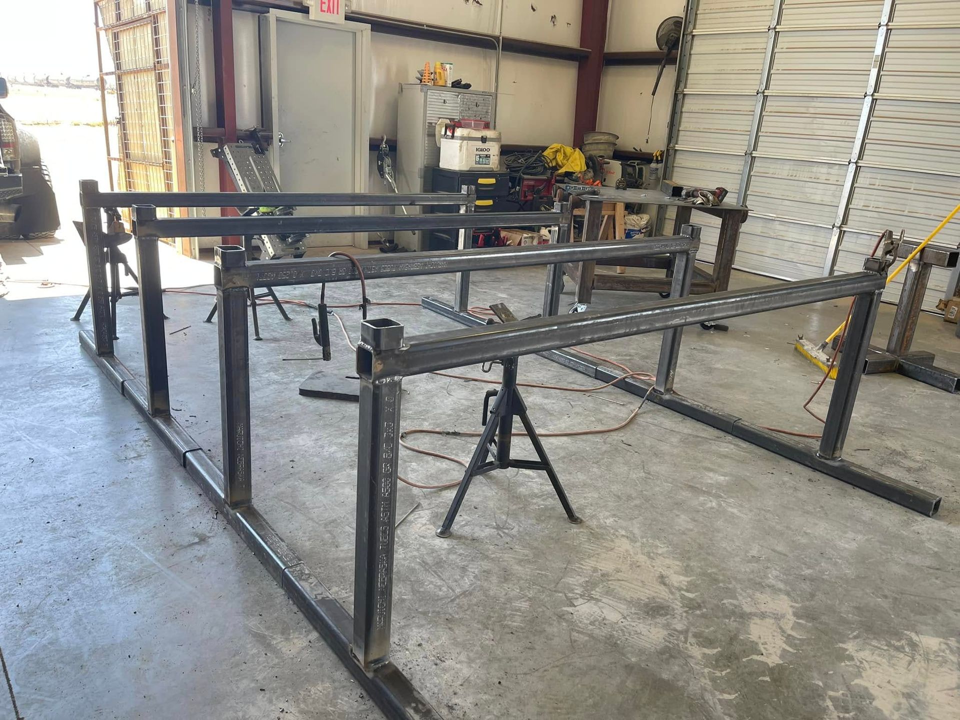 Metal frame structures in a workshop garage with tools and equipment in the background