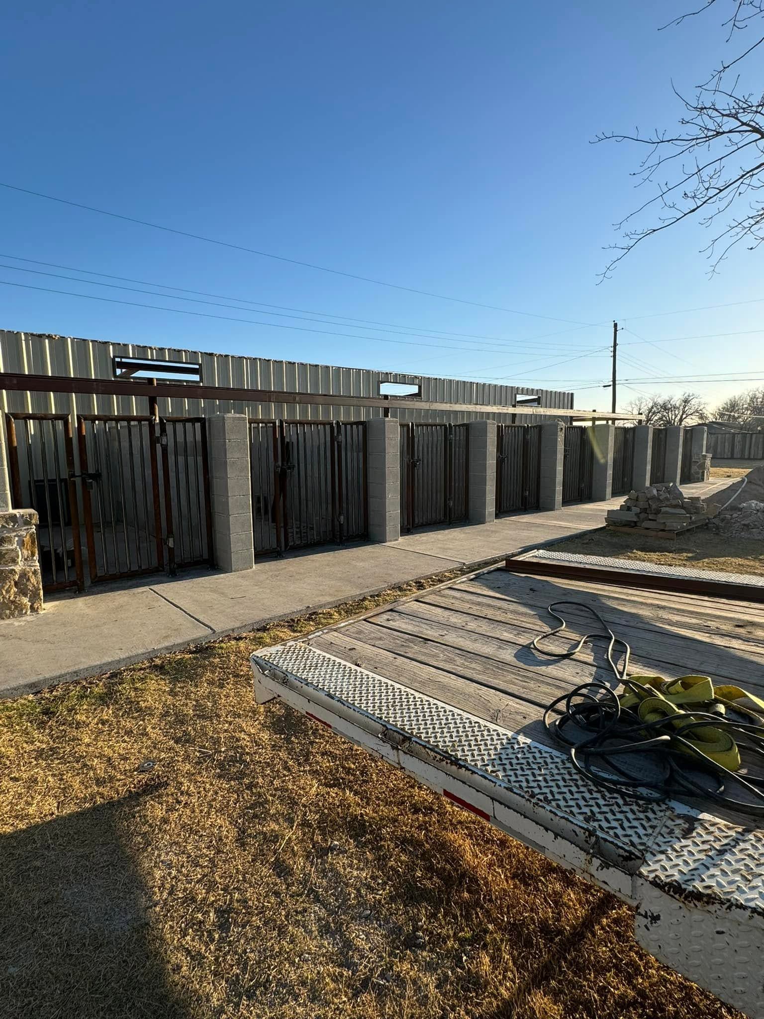 Modern fenced walkway and courtyard with gravel beds under a clear blue sky