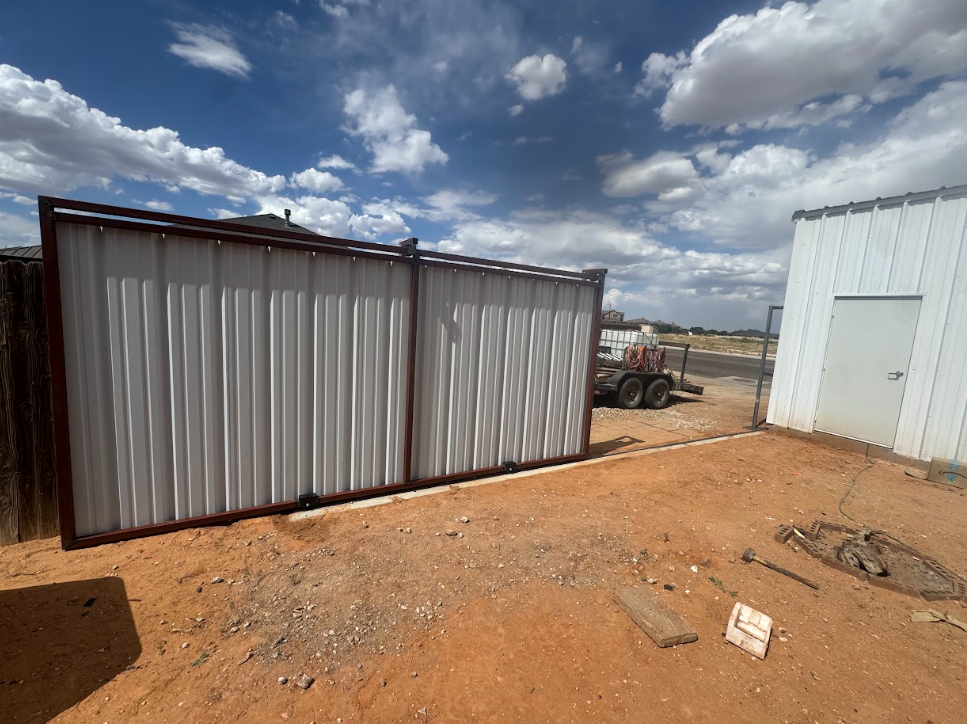 Two metal storage containers on a dirt lot under a cloudy sky, with a truck in the background.