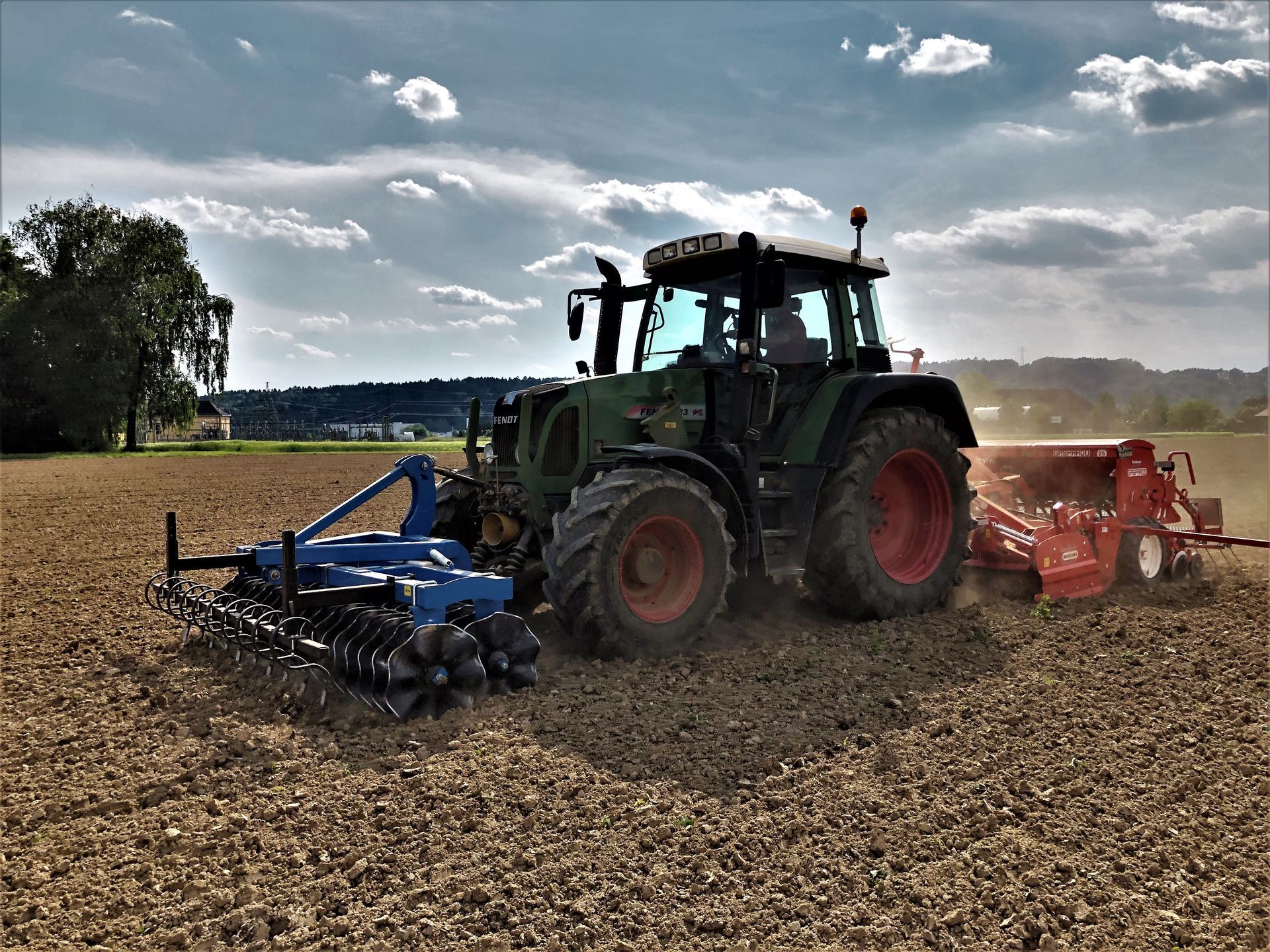 Ein Traktor pflügt ein Feld mit einem daran befestigten Pflug