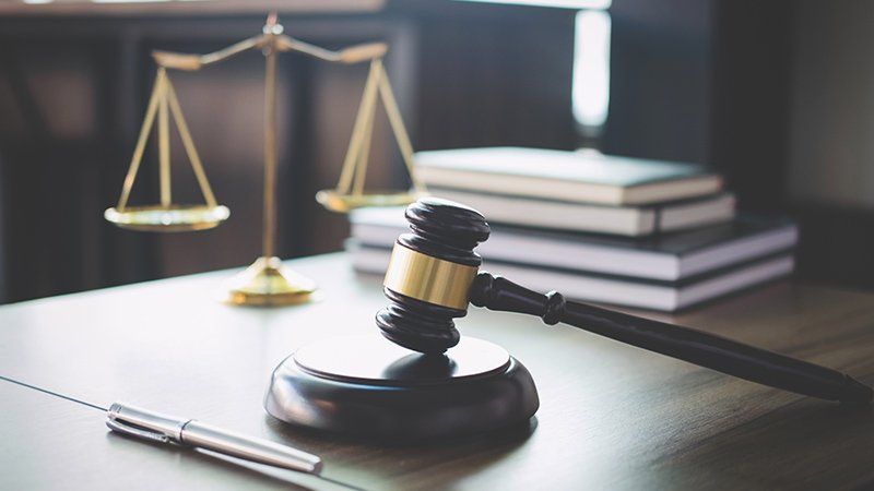 justice scale in background of a gavel