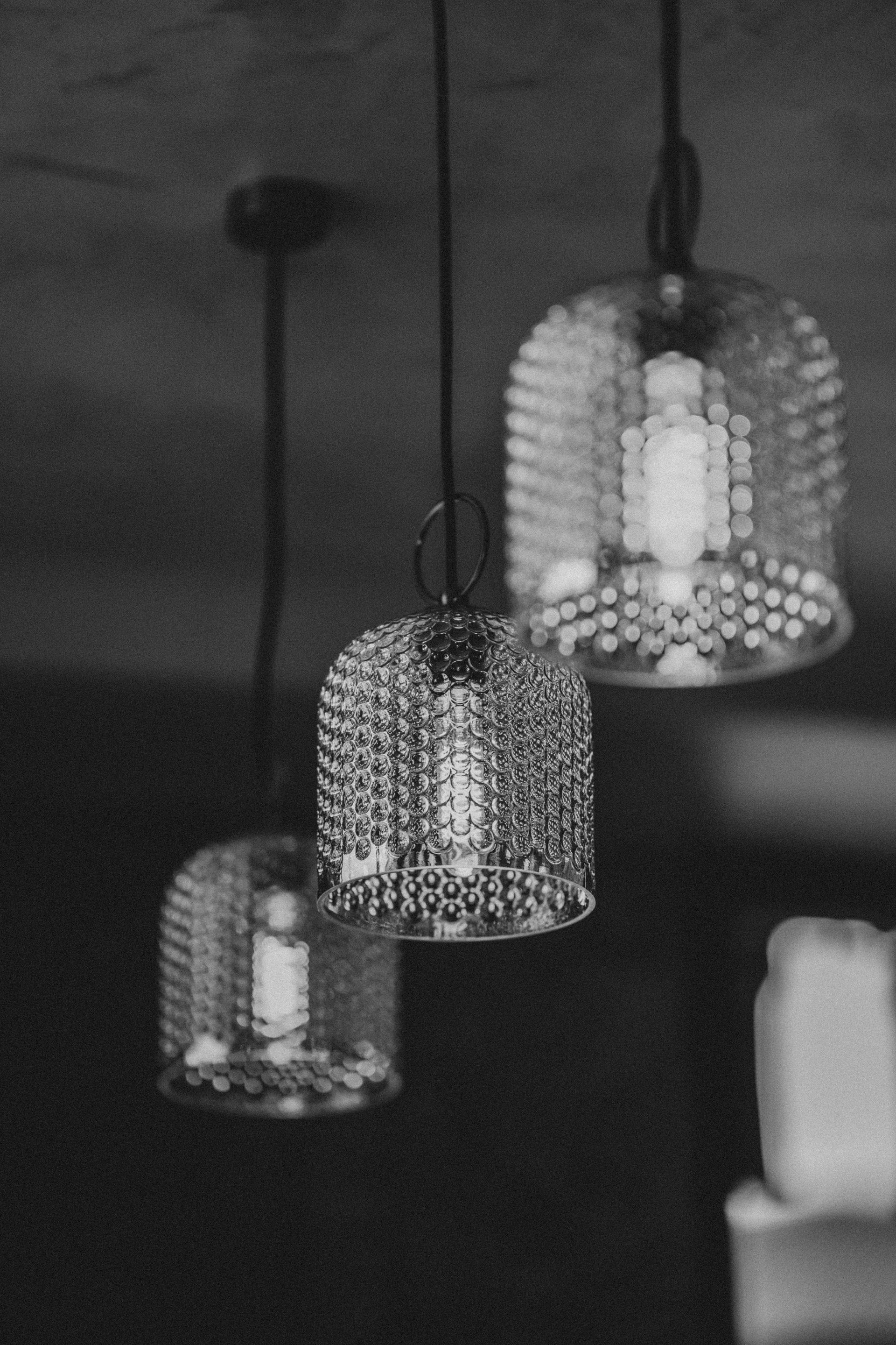 Three hanging pendant lights with geometric shades glowing in a dim room