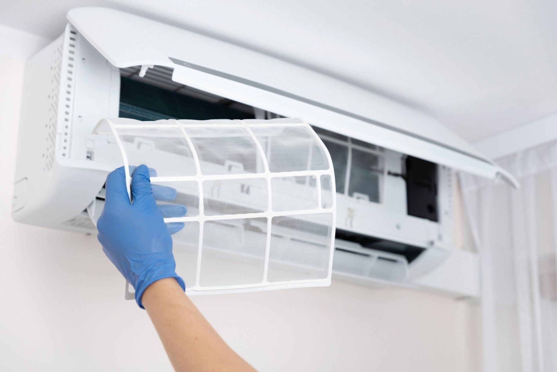 Technician Cleaning Air Conditioner Filter — Broward County, FL — Indoor Air Quality Corporation