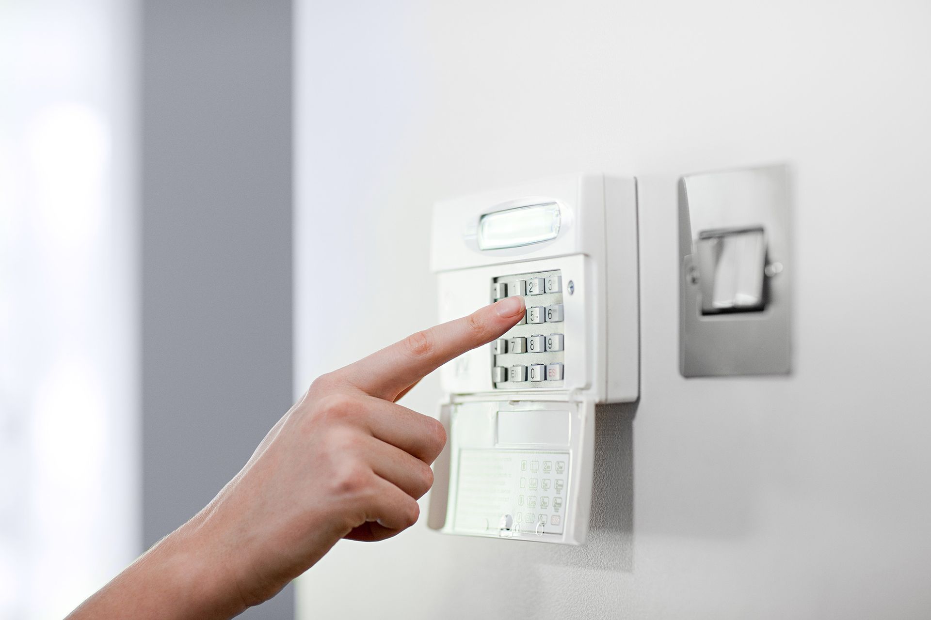 A person is pressing a button on a security system.