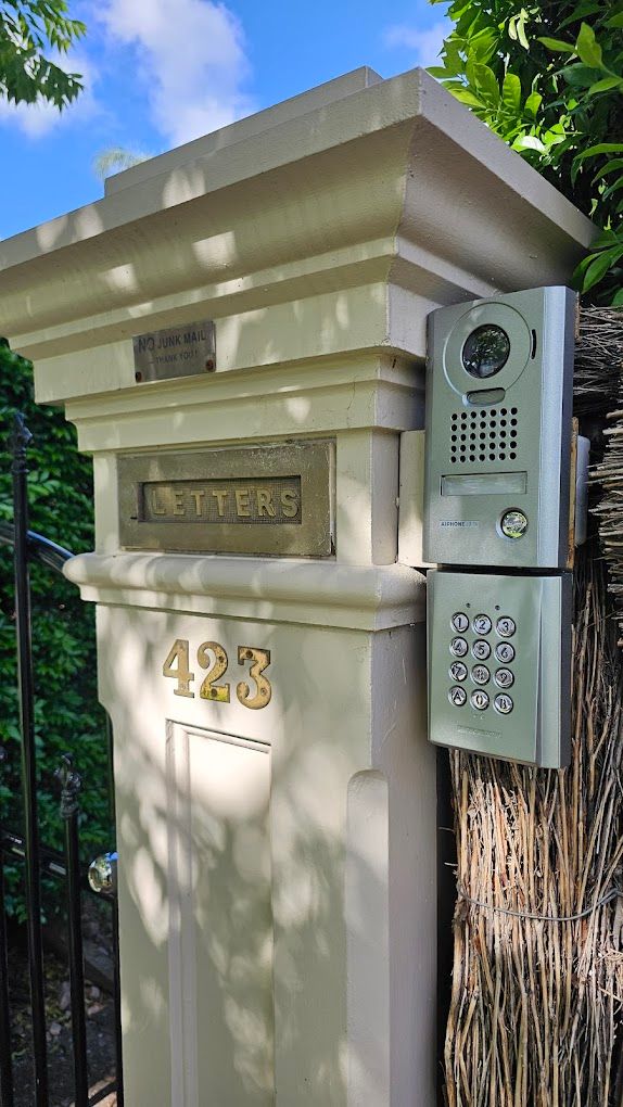 A person is pressing a doorbell on a brick wall.