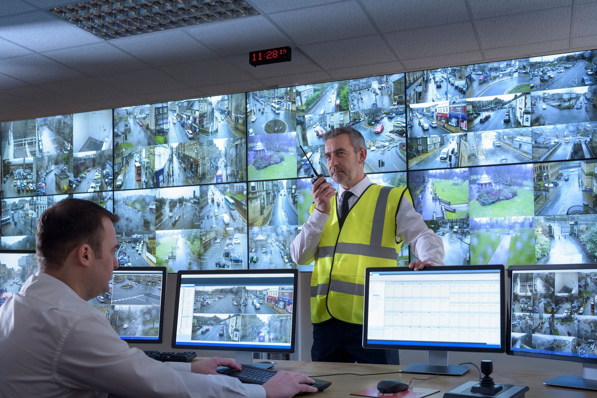Security guards in security control room with video wall.