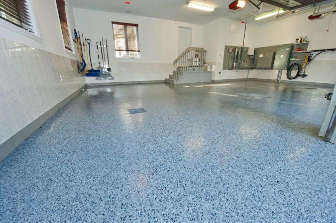 Garage with a speckled blue and gray epoxy floor. Walls are white and light gray.