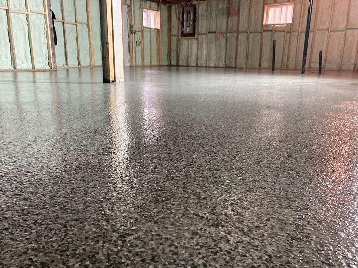 Granite-like epoxy floor in a room with light brown insulated walls.