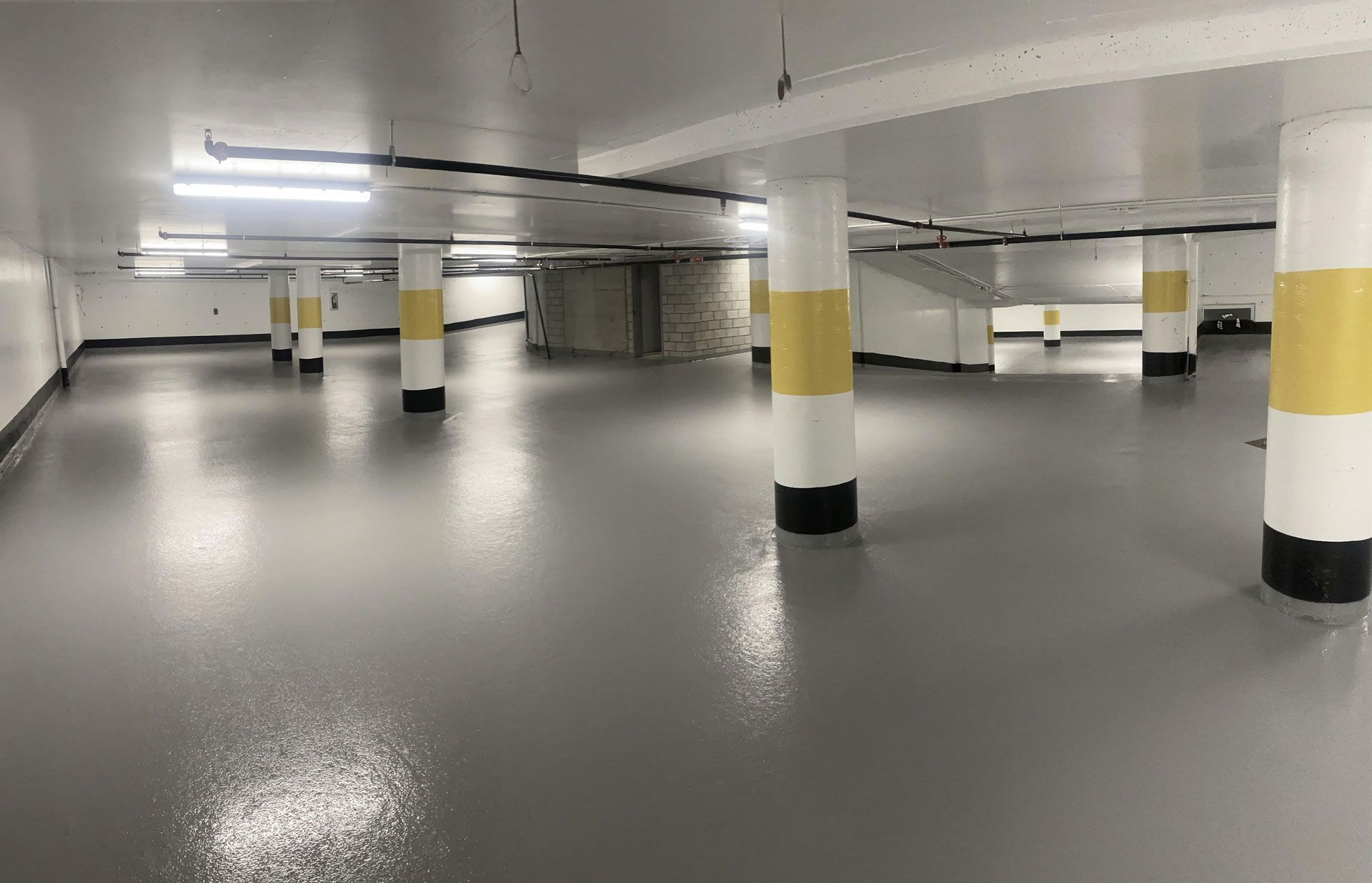 A large empty parking garage with columns and a gray floor.