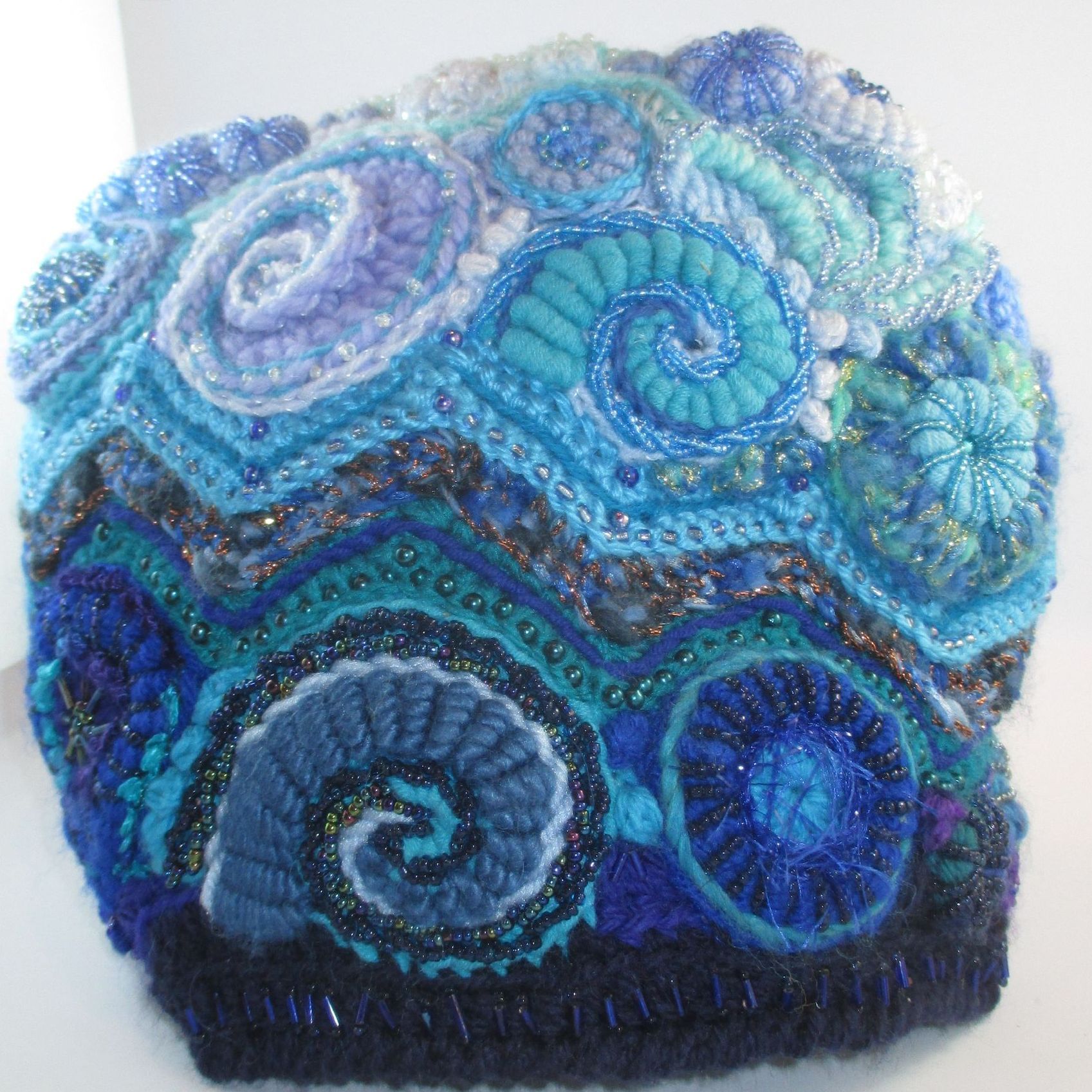 A blue and purple crocheted hat with swirls on it