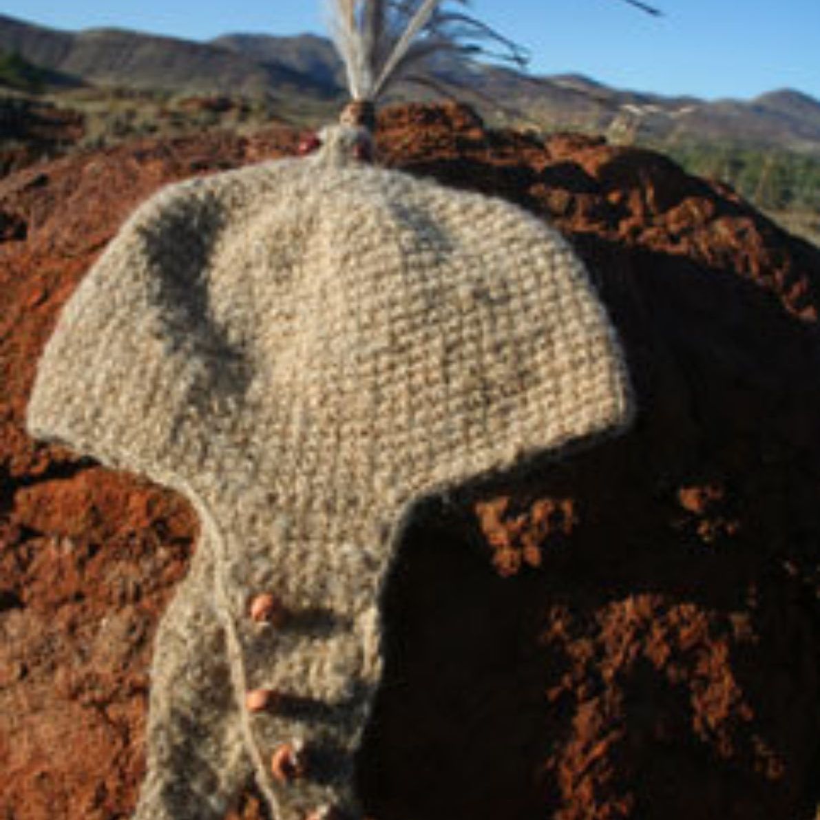 A knitted hat is sitting on top of a pile of dirt.