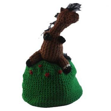 A stuffed horse is sitting on top of a green hill