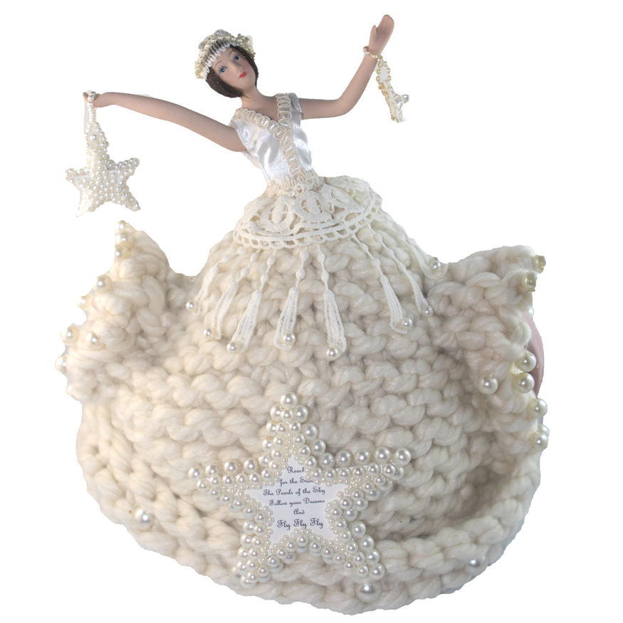 A doll in a white dress is holding two stars