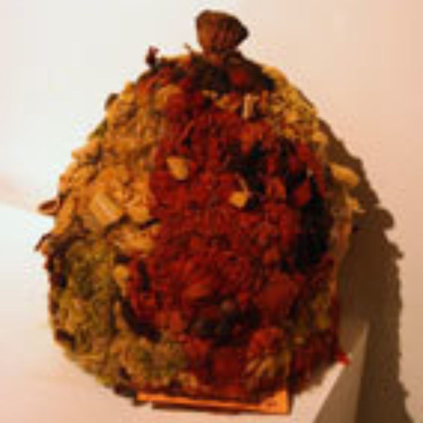 A sculpture of a pumpkin made of leaves is sitting on a table.