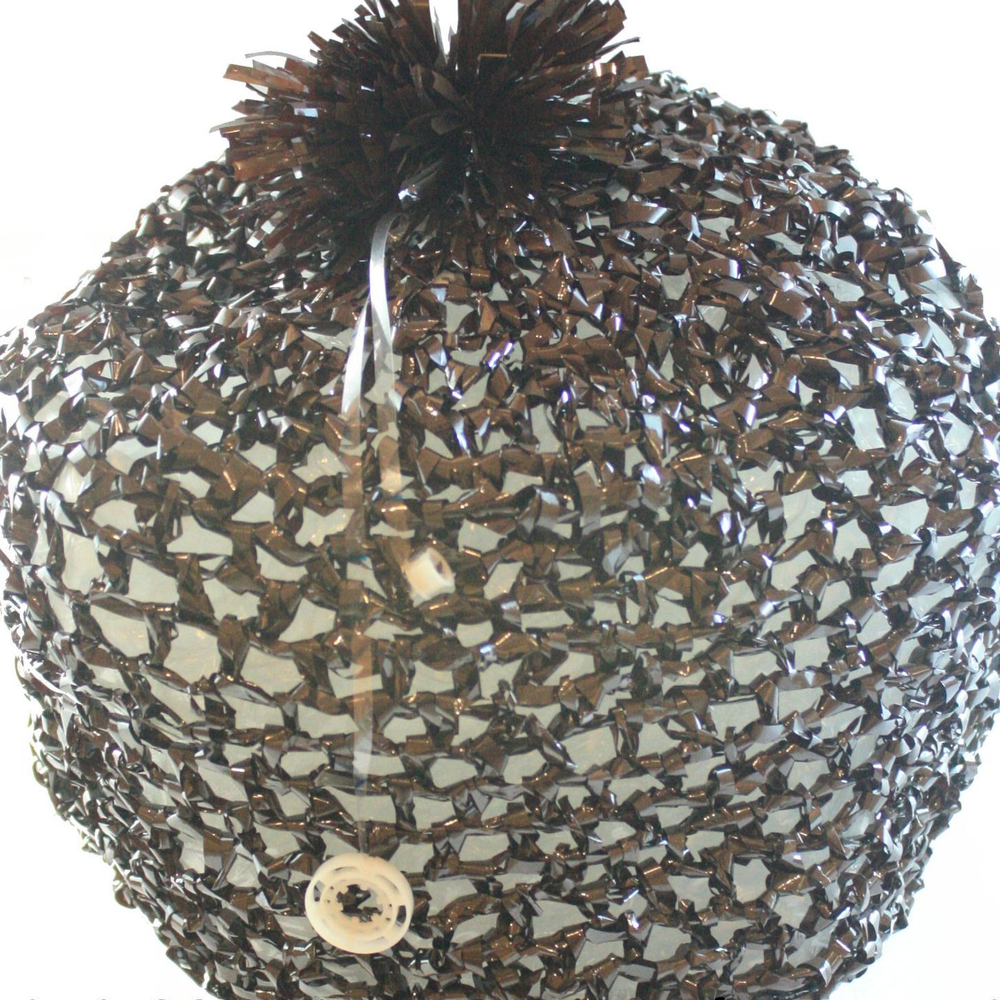 A close up of a knitted object with a button on it