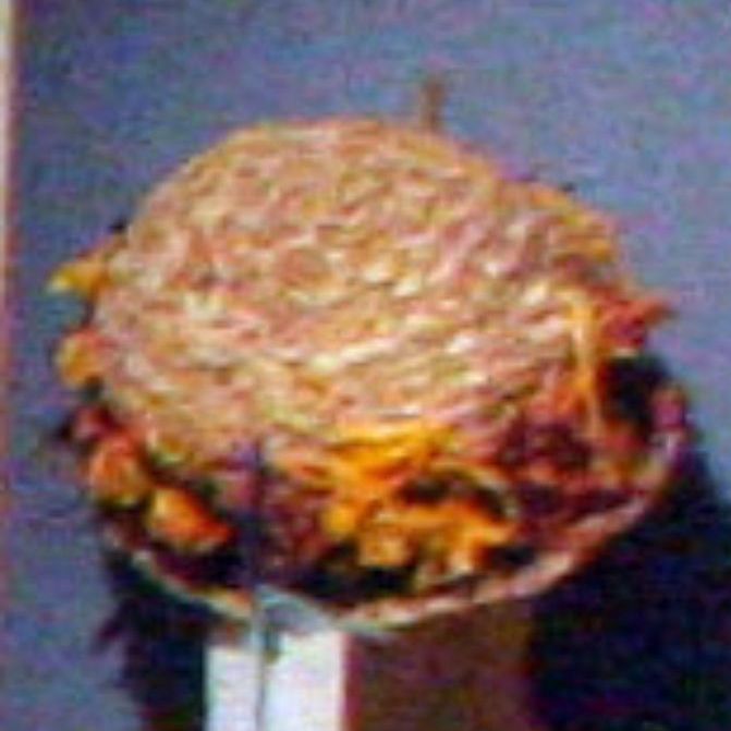 A straw hat with flowers on it looks like a hamburger