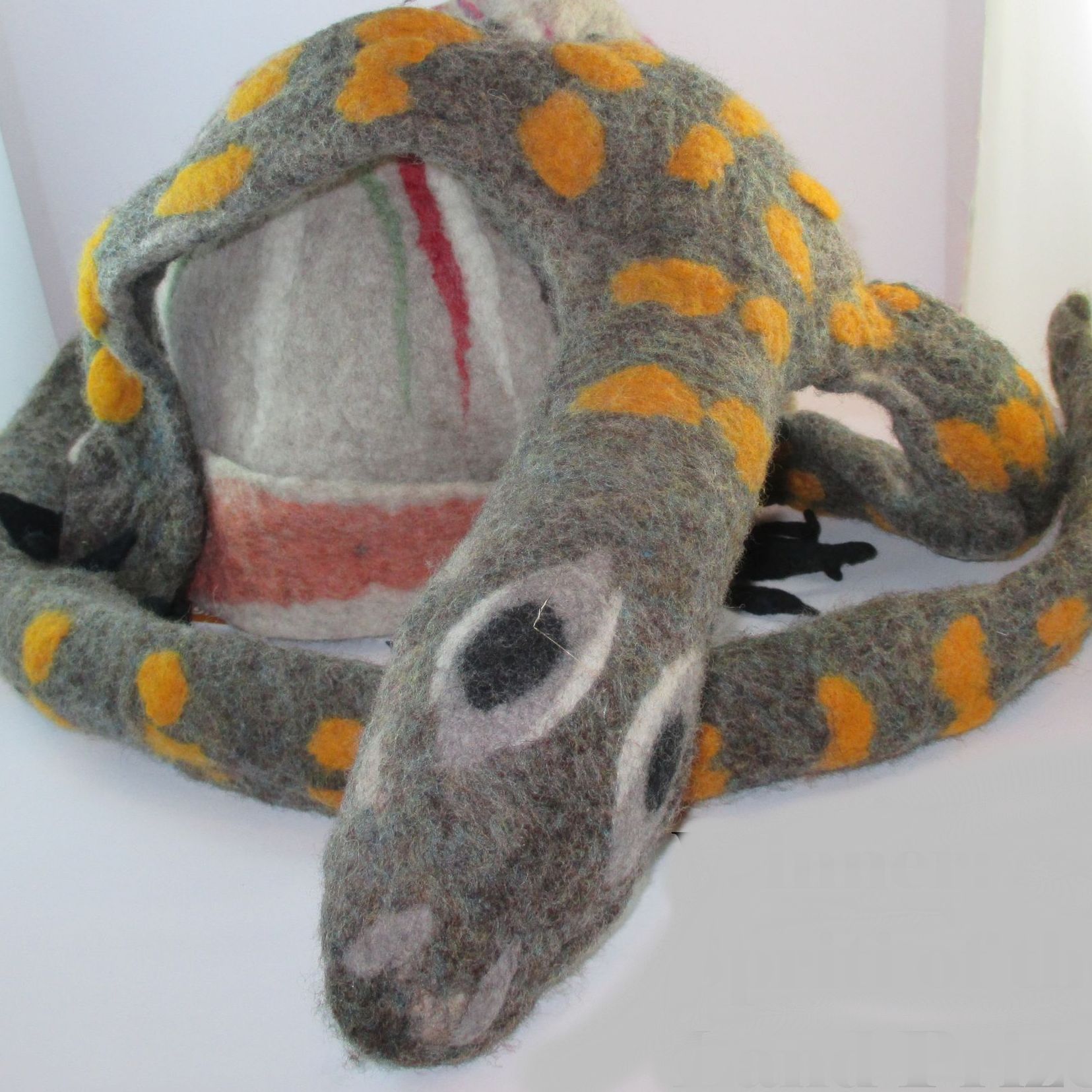 A stuffed animal in the shape of a snake with yellow spots