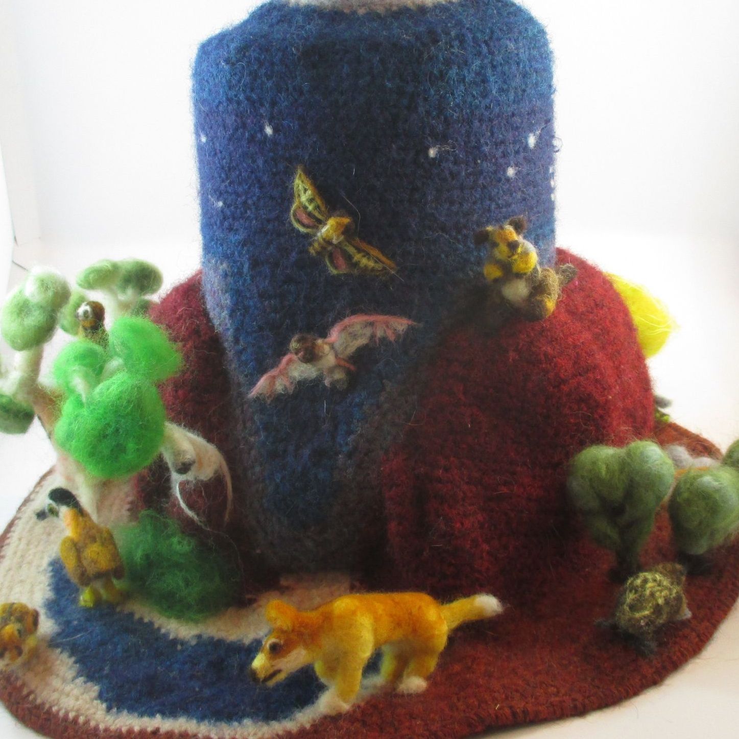A knitted hat with animals and trees on it