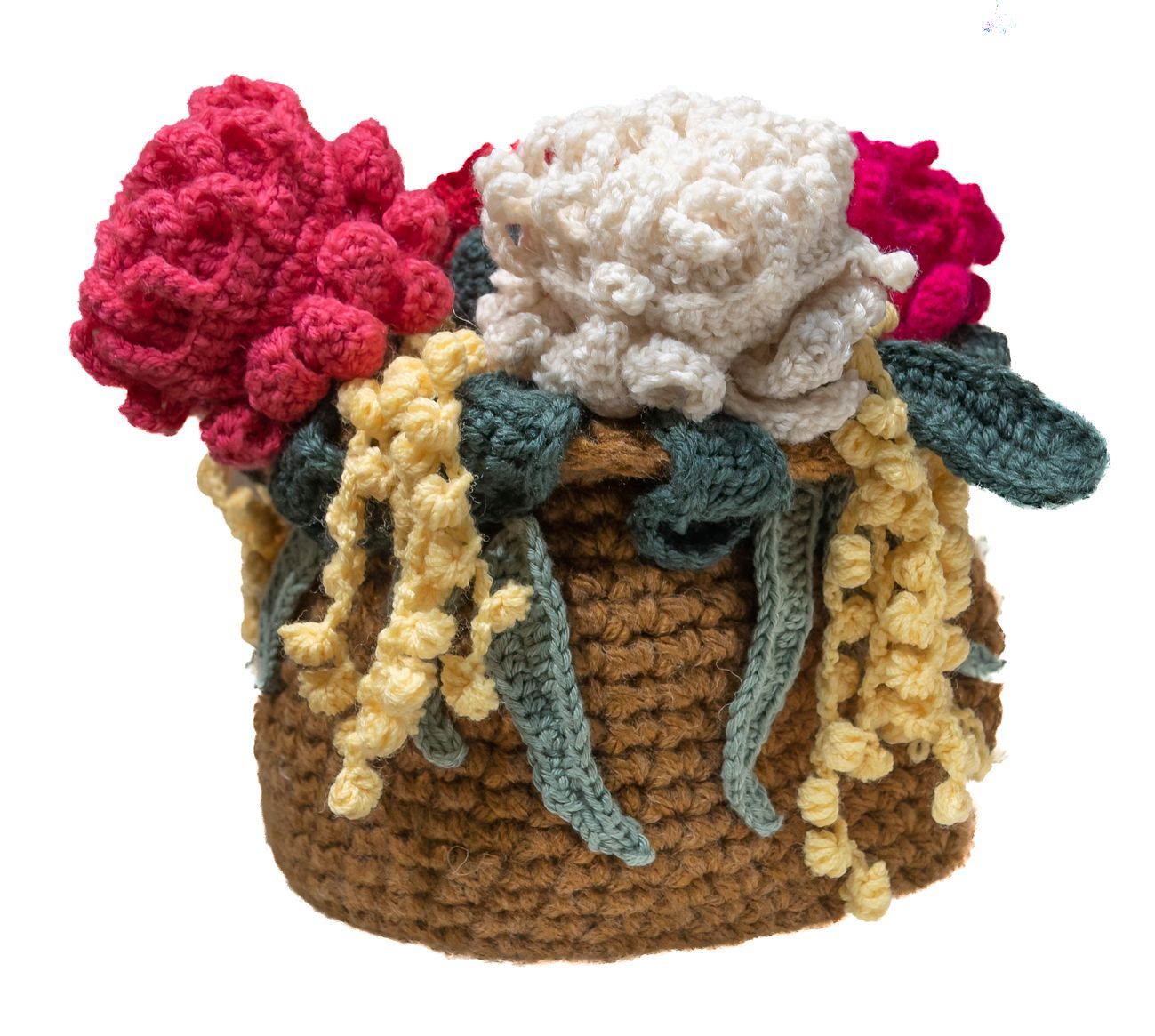 A basket filled with crocheted flowers on a white background