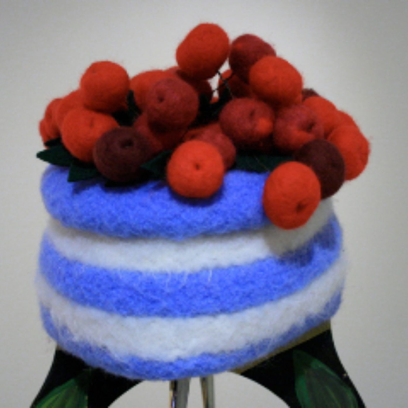 A blue and white striped cake with red berries on top