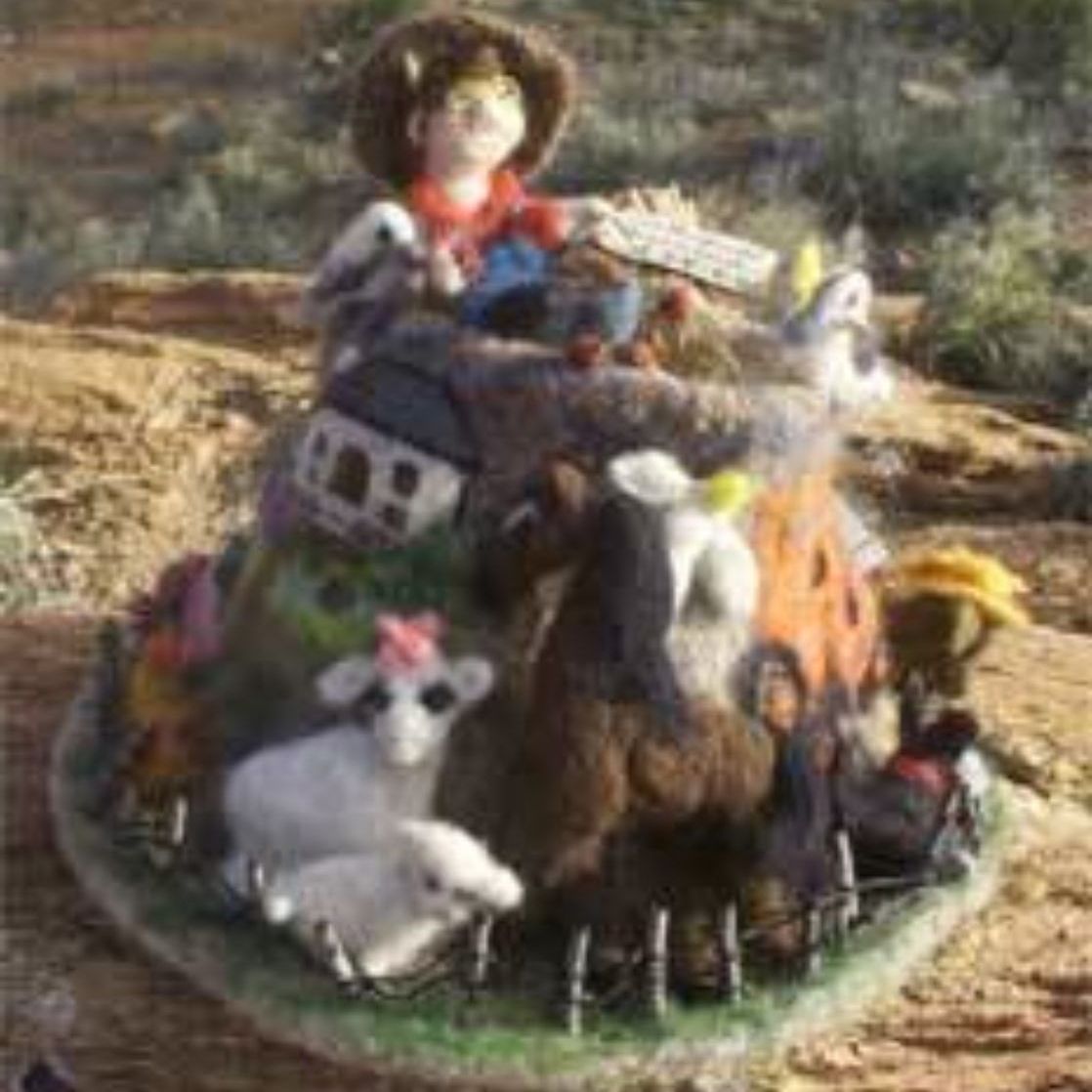 A figurine of a cowboy sitting on top of a pile of animals.