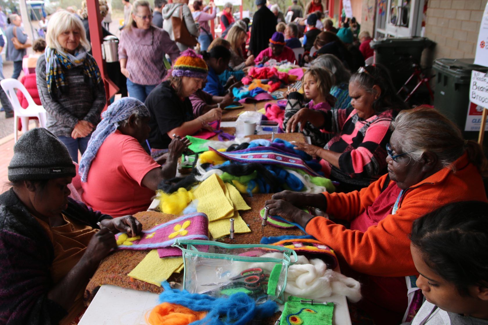 A group of people are sitting around a table making crafts.